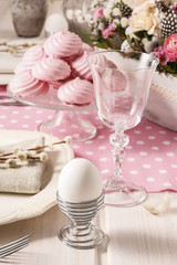 White egg and pink meringues on the easter table