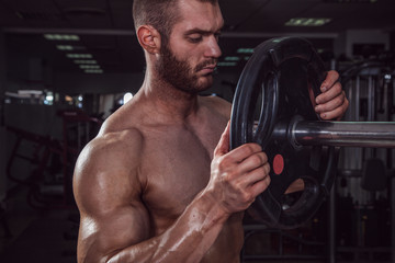 Fototapeta na wymiar Muscular beauty man in gym.
