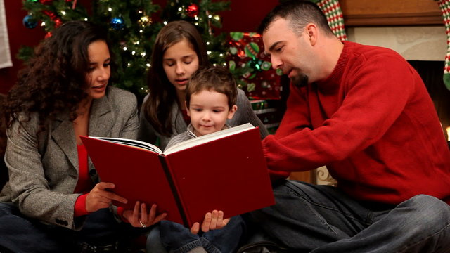 Family reading a book at Christmas time