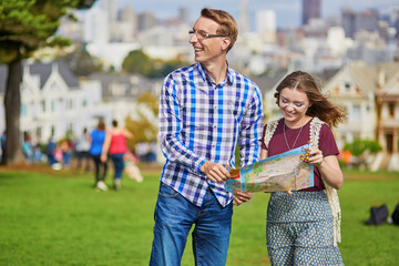 Romantic couple of tourists using map in San Francisco, California, USA