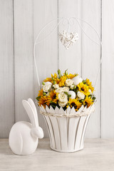 Bouquet of white roses and sunflowers and ceramic rabbit