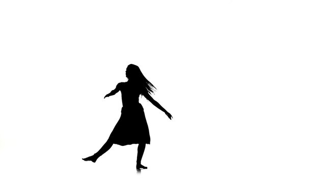 Long-haired woman dancer dancing contemporary dance, jumps and makes split, on white, silhouette, slow motion
