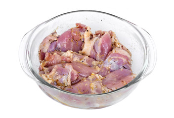 Marinated chicken thighs in bowl on white background
