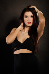 Naklejka premium woman in sensual black dress on dark