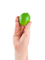 Fresh juicy tasty green lime in a human hand isolated on a white