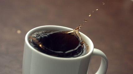 Sugar cube splashing into coffee cup, slow motion - Powered by Adobe