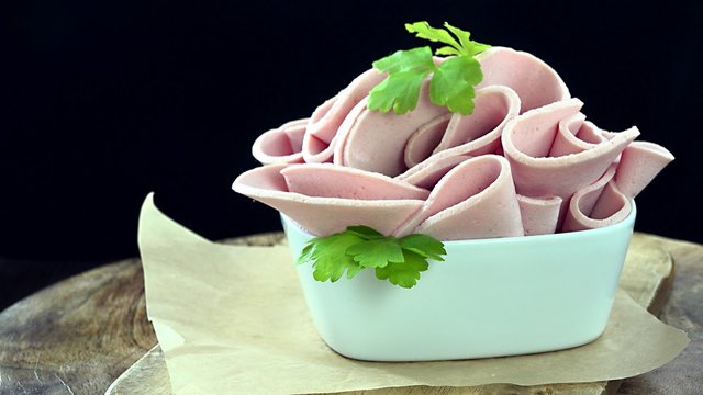 Portion of rotating sliced Mortadella as not seamless loopable 4K footage