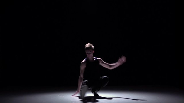 Handsome blonde breakdance style dancer dance, on black, shadow, slow motion