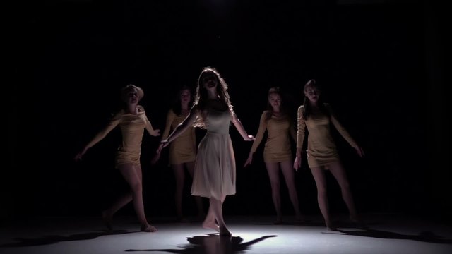 Five beautiful girls continue dancing modern contemporary dance, on black, shadow, slow motion
