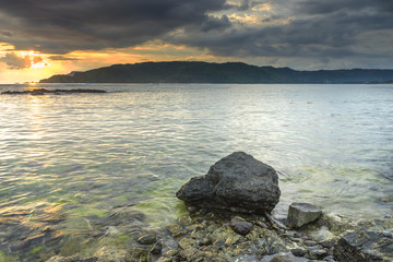 Natural green moss at beach rock with cloudy sunset background