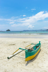 Traditional wooden boat park at sea shore with cloudy skies at South Lombok island, Indonesia