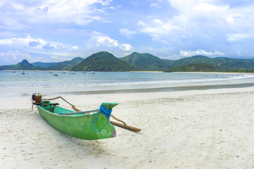 Traditional wooden boat park at sea shore with cloudy skies at South Lombok island, Indonesia