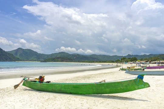 Traditional wooden boat park at sea shore with cloudy skies at South Lombok island, Indonesia