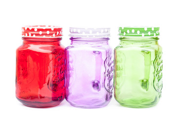 Colourful mason glasses on white background