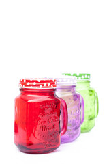 Colourful mason glasses on white background