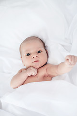 Cute newborn baby boy in the bed