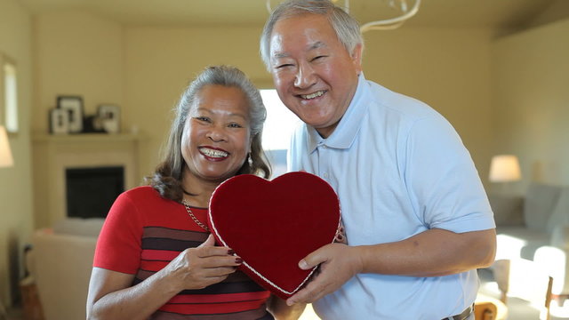 Senior man and woman holding hearts