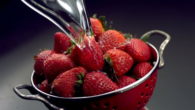 Rinsing strawberries in colander
