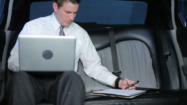 Businessman working in a limo
