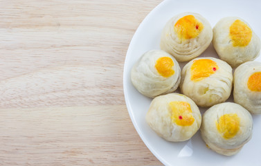 Chinese Pastry Mung Bean or Mooncake with Egg Yolk on dish and wooden table