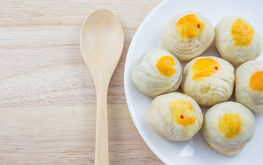 Chinese Pastry Mung Bean or Mooncake with Egg Yolk on dish and wooden table spoon