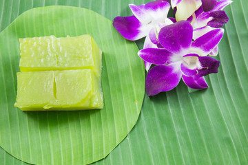 Kind of Thai sweetmeat, Multi Layer Sweet Cake (Kanom Chan) on banana leaf with orchid flower