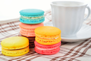 close up of colorful macarons and cup of coffee