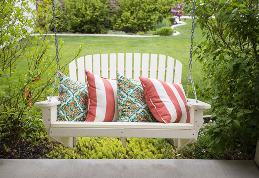 Beautiful wooden front porch swing with comfortable pillows