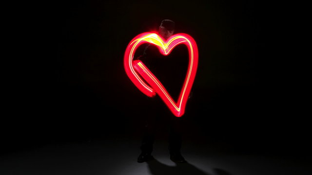 Man painting heart shape with light, stop motion
