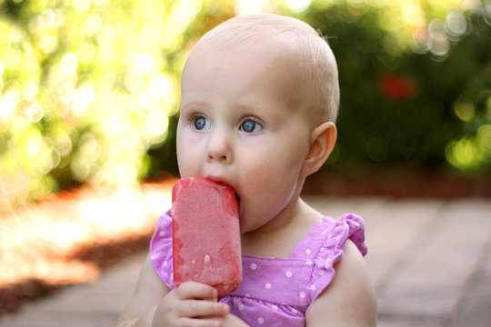 Cute Baby Girl Eating Frozen Fruit Popsicle