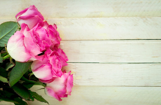 Pink roses on the wooden table