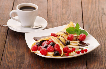 Cup of coffee and pancakes with berries