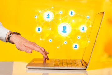 Close up of hand with laptop and social media icons