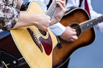 musicians playing on acoustic guitar