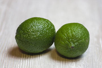 Two limes on wooden table
