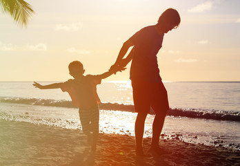 silhouettes of father and son having fun at sunset