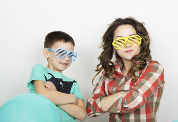 brother and sister, wearing glasses in the style of disco. fold one's arms