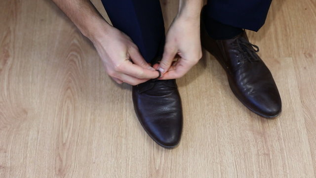 Man tying patent leather shoes formal and festive dressing.