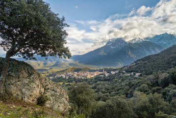 Village of Moltifao in Corsica with snow covered mountains behin