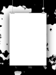 Obraz premium Close-up of one hanged paper sheet with clips on black and white ink splotchy background