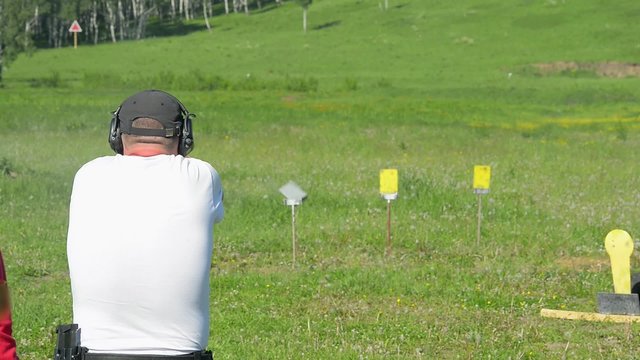 Man shoot with a gun in targets on shooting range. 