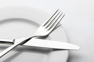 Plates and cutlery on a wooden table - obrazy, fototapety, plakaty