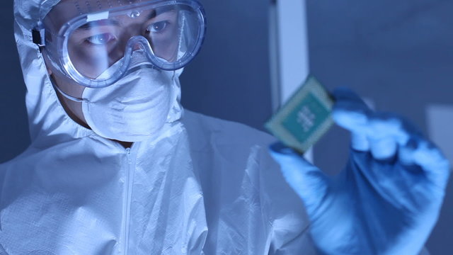 Man In Clean Room Holds Up Computer Cpu Microchip