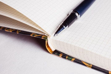 Open notebook and pen on a white background