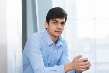 Businessman leaning on balcony railings