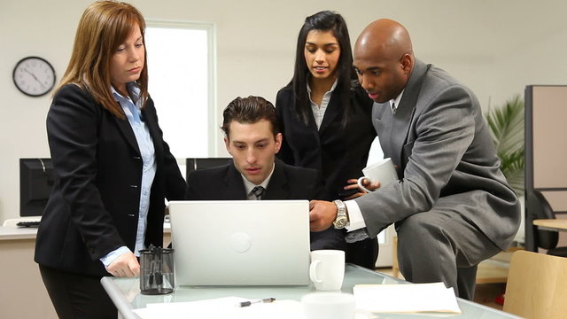 Group of businesspeople look at computer