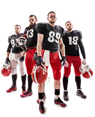 The four american football players posing with ball on white background