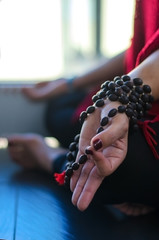 Women Meditating in lotus pose with mala beads