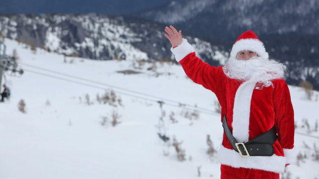 Santa Claus snowboarder waves to camera