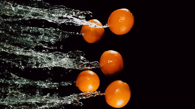 oranges are flying with a jet of water, slow motion, back background